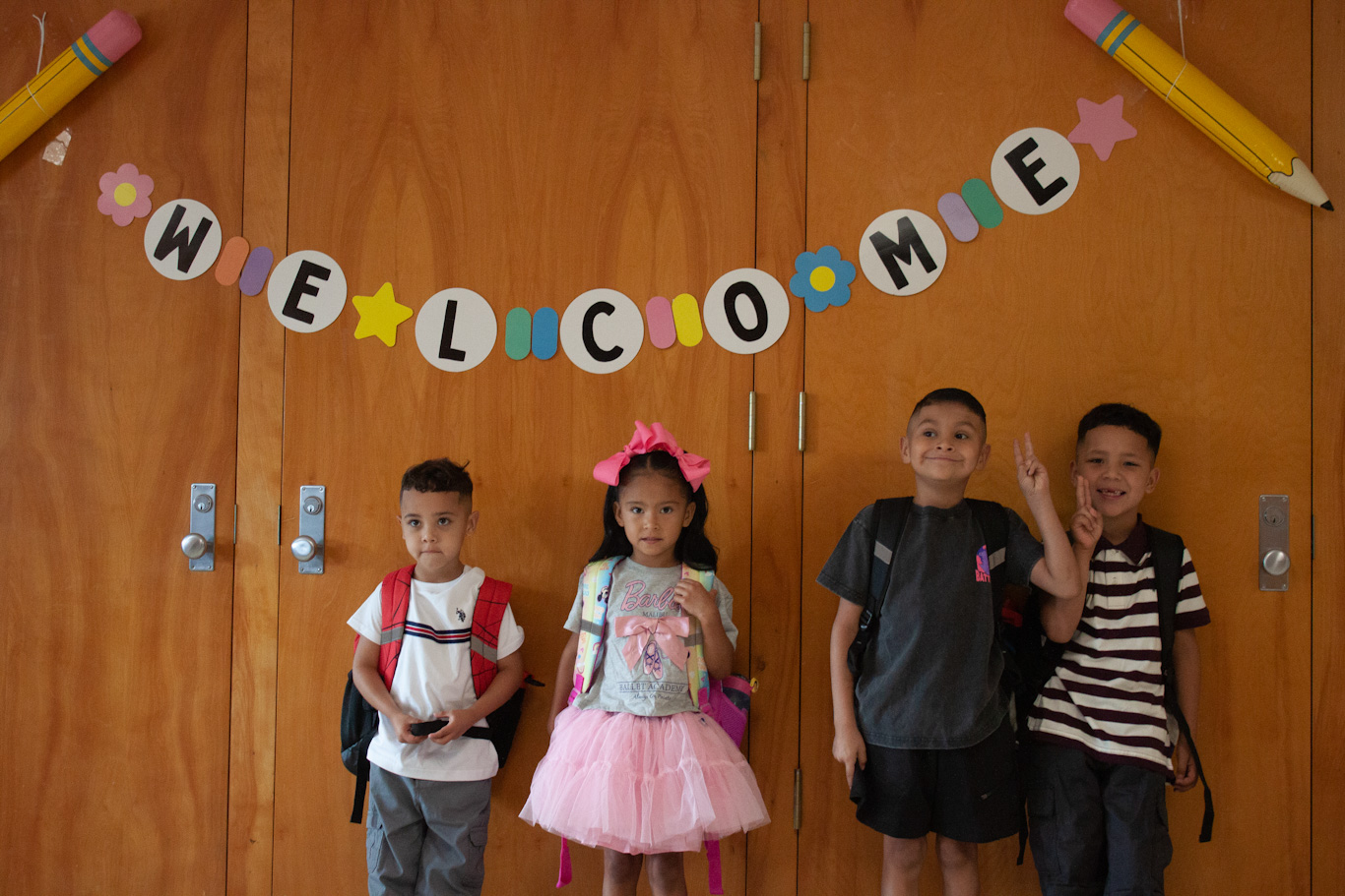Four students pose under the Welcome banner