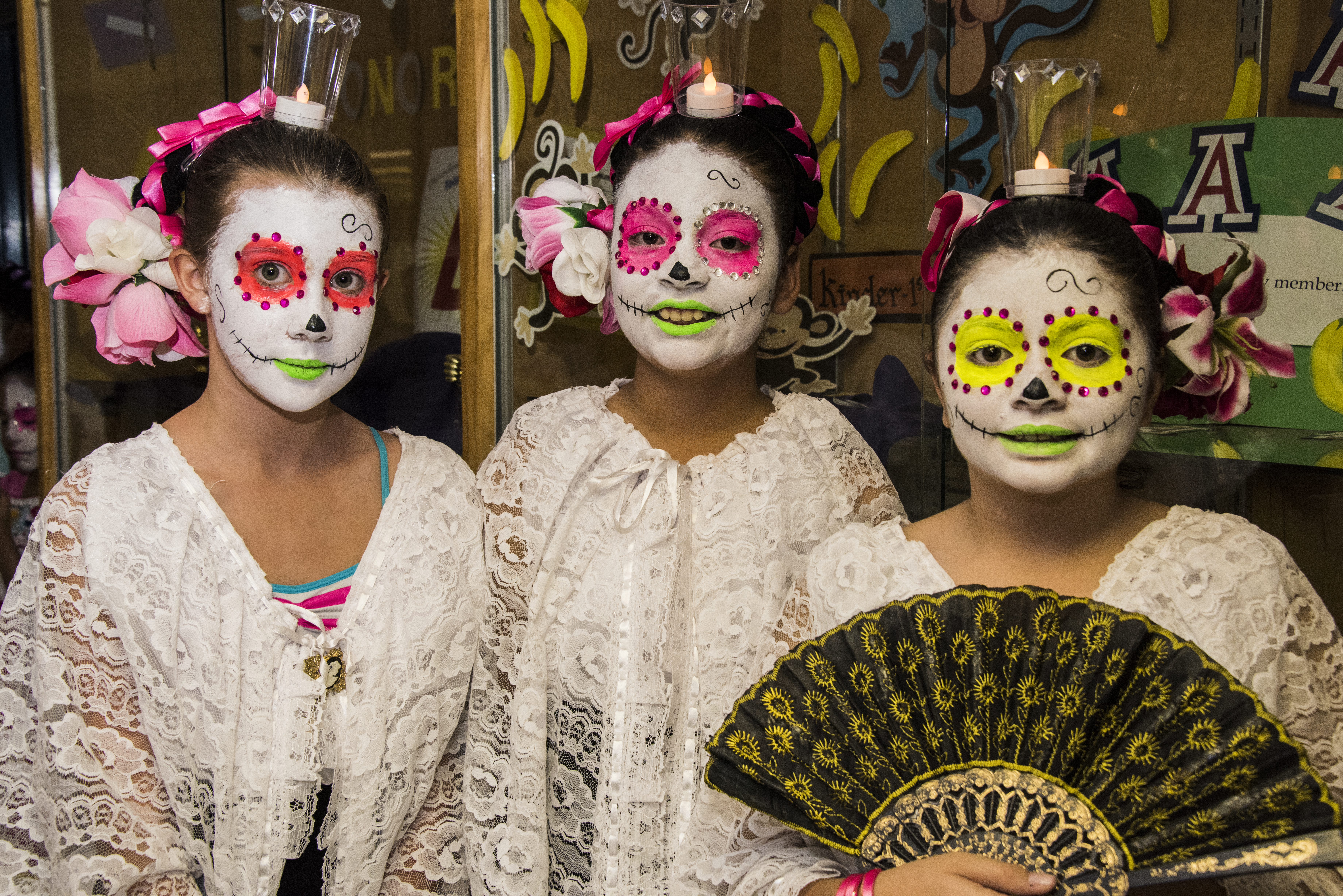 Three girls in Day of the Dead makeup smile before their performance